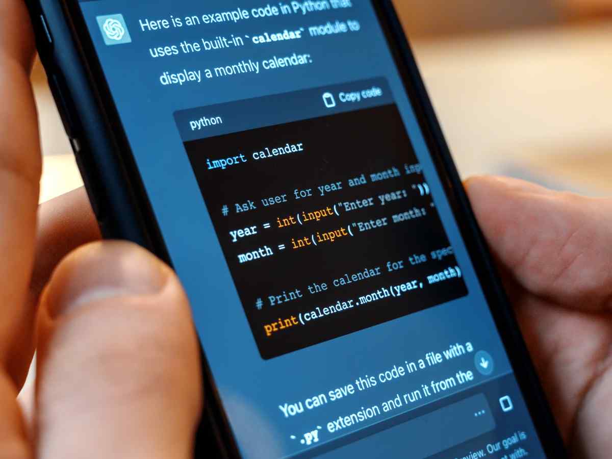 Pessoa a usar o ChatGPT no seu telemóvel para mostrar um código em Python.
