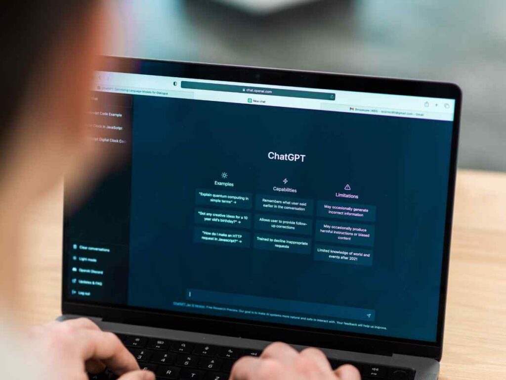 Pessoa a utilizar o ChatGPT num computador portátil para escrever e gerar ideias para o seu projeto de mestrado.