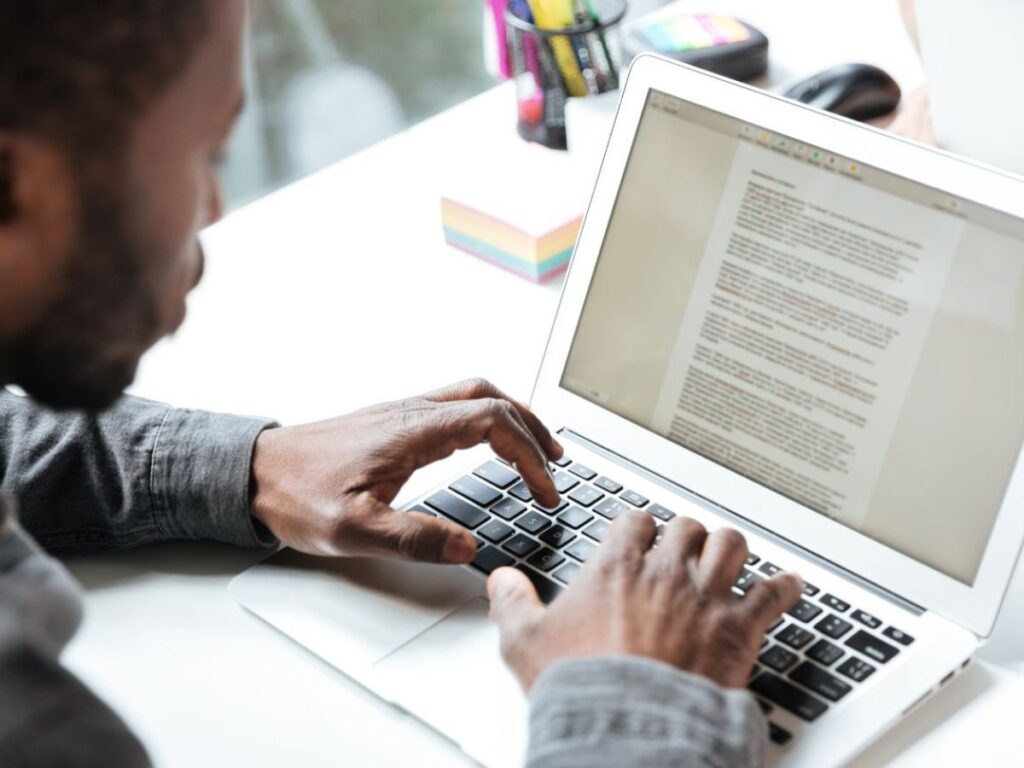Rapaz trabalhando em um computador aplicando os passos para criar um índice no Word conforme o artigo