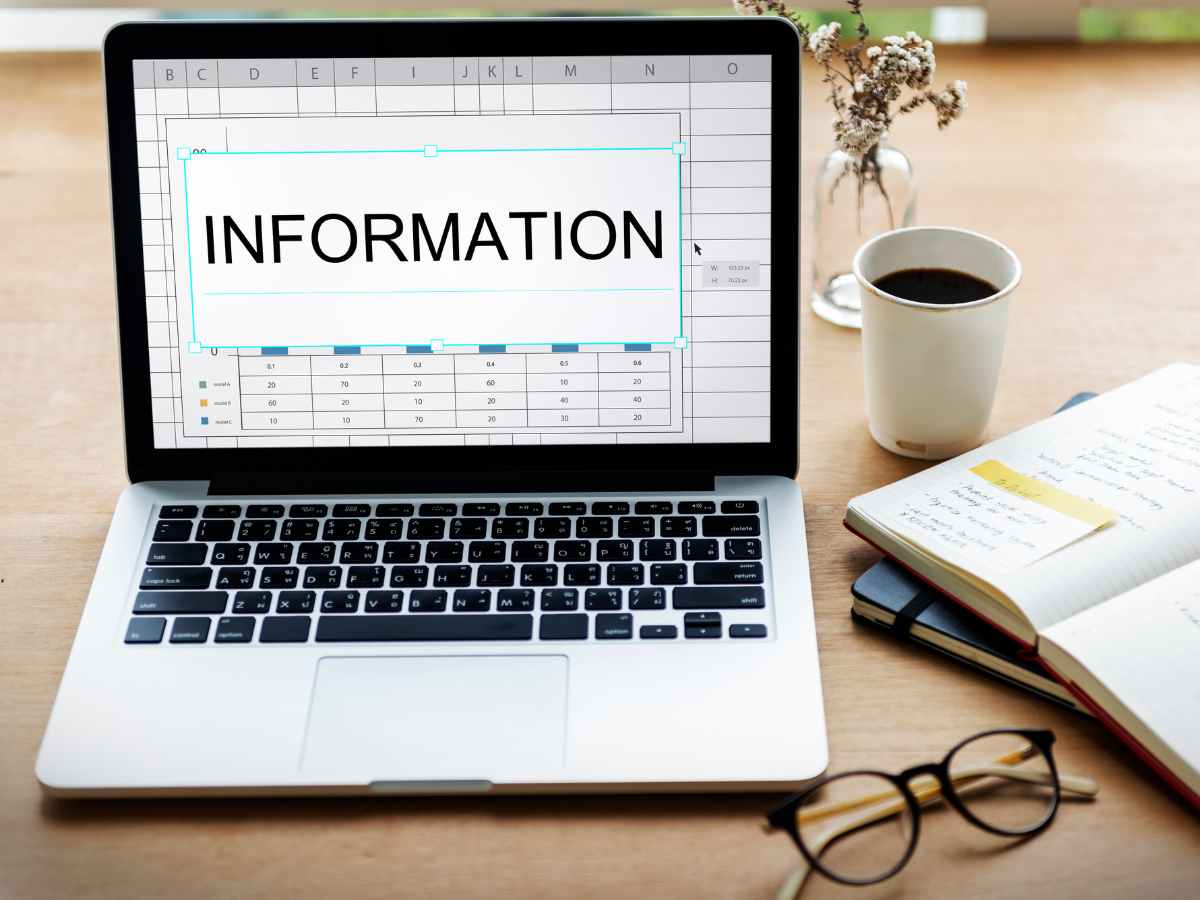 Imagem de um laptop mostrando uma planilha de dados com a palavra 'INFORMATION' em destaque na tela.